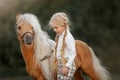 Little girl with palomino miniature horse in summer day Royalty Free Stock Photo