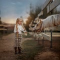 Little girl with palomino pony horse insurer day Royalty Free Stock Photo