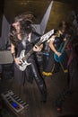 Long-haired man headbanging and playing guitar with a pedals board next to a bass player Royalty Free Stock Photo