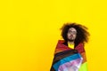 long-haired man wrapped in intersex-inclusive progress pride flag