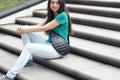 Long haired millenial woman in mint t-shirt and white jeans with