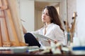 Long-haired woman paints picture on canvas Royalty Free Stock Photo