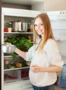 Long-haired woman with pan near opened refrigerator Royalty Free Stock Photo