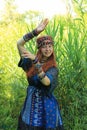 Long-haired young Caucasian girl with red hair in a traditional dress adorned with many African necklaces Royalty Free Stock Photo