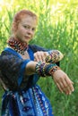 Long-haired young Caucasian girl with red hair in a traditional dress adorned with many African necklaces Royalty Free Stock Photo