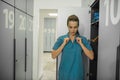 Long-haired young female doctor changing clothes in the locker room