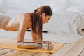 Woman with bionic prosthesis looks at wristwatch doing plank Royalty Free Stock Photo