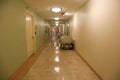 Long hallway in a hospital with a vacant bed