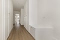 Long hallway of a house with built-in wardrobes with white wooden doors and access to several rooms Royalty Free Stock Photo