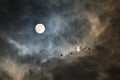 Long-haul night flight through clouds in light of full moon Royalty Free Stock Photo