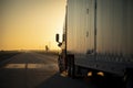 Long Haul 18 Wheel Truck driving on a highway at sunrise or sunset Royalty Free Stock Photo