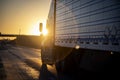 Long Haul 18 Wheel Truck driving on a highway at sunrise or sunset with hazy orange sky Royalty Free Stock Photo