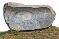 Long horizontal monument of rough red granite stone lie on grass isolated