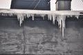 Long icicles hang from the edge of a flat roof cold winter Royalty Free Stock Photo