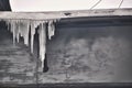 Long icicles hang from the edge of a flat roof cold winter Royalty Free Stock Photo