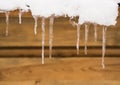 Long icicles hang from the roof of the house Royalty Free Stock Photo