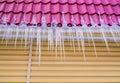 Long icicles hang from the roof of the house Royalty Free Stock Photo