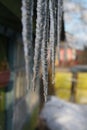 Long icicles hanging from the roof line and melt Royalty Free Stock Photo