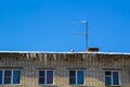 Long icicles and snow hang on the eaves of the house roof Royalty Free Stock Photo