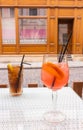 Long Island cocktail and Spritz Aperol with straws on table. Mixed alcoholic cocktails on table. Drinks in outdoor bar. Royalty Free Stock Photo