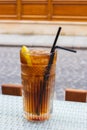 Long Island cocktail with two straws on table, isolated. Mixed alcoholic cocktail on table. Drinks in outdoor bar. Summer party. Royalty Free Stock Photo