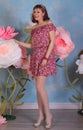 Long legged brunette girl in white fishnet stockings and minidress posing at the flowers Royalty Free Stock Photo