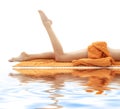 Long legs of girl with orange towel on white sand Royalty Free Stock Photo