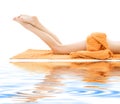 Long legs of relaxed lady with orange towel Royalty Free Stock Photo