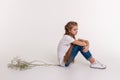 Upset young girl with extremely long hair sitting in closed posture