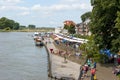 A long line of book stalls crowded with people along the riverside