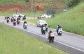 Long line of motorbikes travelling onto freeway onramp