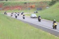 Long line of motorbikes travelling onto freeway onramp