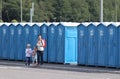 A long line of portable toilets in an outdoor event