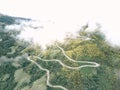 long lonely narrow road with many curves in the valley among the vegetation and trees on a foggy day, ruta del cares