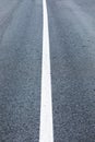 Long lonely old asphalt road vertical background with a white solid stripe Royalty Free Stock Photo