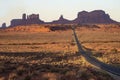 A long lonely road leads to icons of Monument Valley. Royalty Free Stock Photo