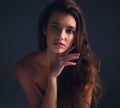 Long and luscious hair to bear. Studio shot of an attractive young woman posing against a dark background.