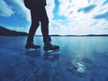 Long male legs in black leggins with hockey skates. Outdoor ice skating