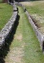 long mule track bordered by a stone wall in the mountains withou