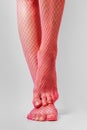 Long muscular female legs in sexy pink fishnet tights Royalty Free Stock Photo