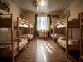 Long, narrow room with several bunk beds. There are two rows of bunks in room, each row containing four beds. The bunks