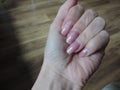 Elegant Nails in Bloom: A Close-Up of a Hand with Delicate Pink Nails