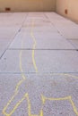 Long neck yellow giraffe silhouette painted on a pavement sidewalk with chalk