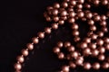 Long necklace of brown beads on a dark background Royalty Free Stock Photo