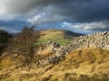 A long old dry stone wall running along a rural landscape scene Royalty Free Stock Photo