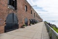 Long Old Historic Brick Building in Red Hook Brooklyn with an Empty Walkway along the Water Royalty Free Stock Photo