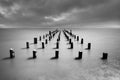 Long old wooden pier bridge extents from beach to sea. Deep cloudy sky after the big storm. Expectation to success dreams. Royalty Free Stock Photo