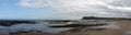 Long panoramic view of the beach at Scarborough south bay with the castle and hotels in the distance
