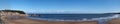 Long panoramic view of the beach at Scarborough south bay on a sunlit summer day with the town harbour and lighthouse in the Royalty Free Stock Photo