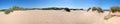 A long panoramic view of grass covered coastal sand dunes in front of the sea in formby merseyside on a bright summer day Royalty Free Stock Photo